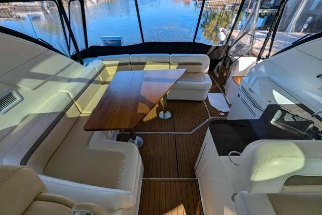 Nautalia Yacht Photos Pics Luxurious interior of 2013 Sea Ray 470 Sundancer yacht with elegant seating and wooden table.