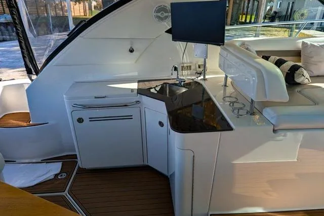 Nautalia Yacht Photos Pics Luxurious interior of 2013 Sea Ray 470 Sundancer yacht with kitchenette and seating area.