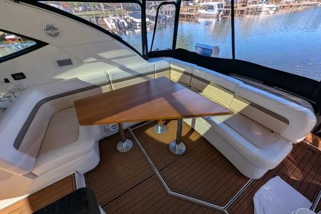 Nautalia Yacht Photos Pics 2013 Sea Ray 470 Sundancer interior with elegant seating and wooden table, overlooking marina.