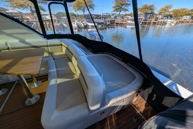 Nautalia Yacht Photos Pics 2013 Sea Ray 470 Sundancer interior with seating and table, overlooking marina.