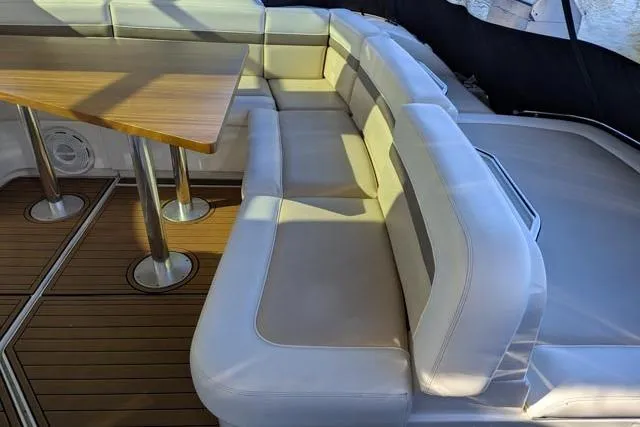 Nautalia Yacht Photos Pics Luxurious seating area on 2013 Sea Ray 470 Sundancer yacht with wooden table.