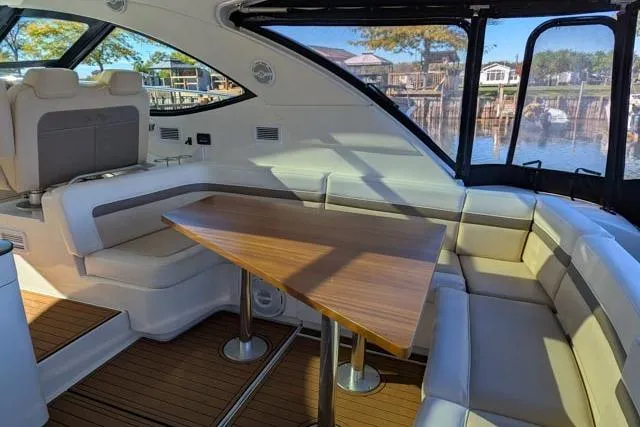 Nautalia Yacht Photos Pics Luxurious interior of 2013 Sea Ray 470 Sundancer yacht with elegant seating and wooden table.