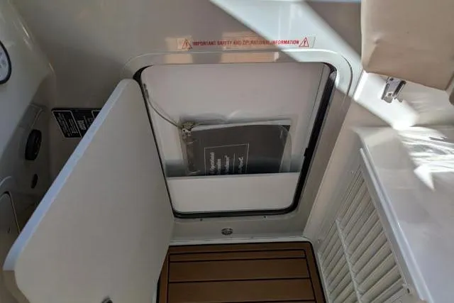 Nautalia Yacht Photos Pics 2013 Sea Ray 470 Sundancer interior storage compartment with manual and wooden flooring.