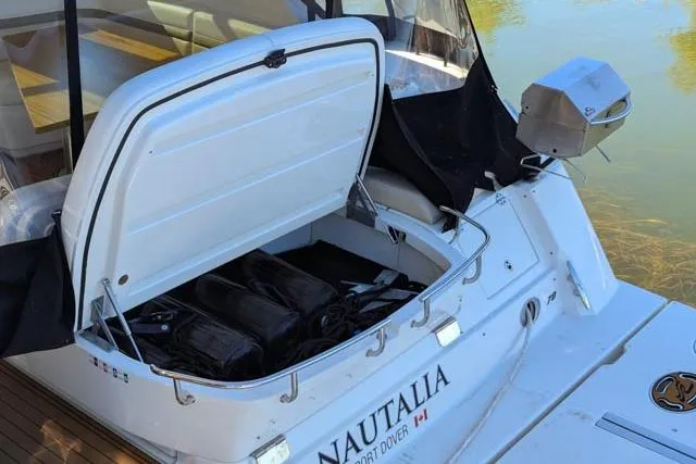 Nautalia Yacht Photos Pics 2013 Sea Ray 470 Sundancer yacht with open storage compartment, docked on calm water.