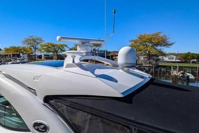 Nautalia Yacht Photos Pics 2013 Sea Ray 470 Sundancer yacht with radar equipment, docked near trees and buildings.