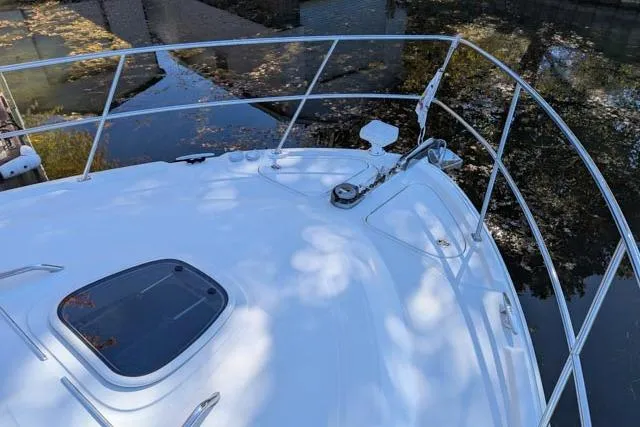 Nautalia Yacht Photos Pics 2013 Sea Ray 470 Sundancer yacht bow with railing and hatch, docked by water.