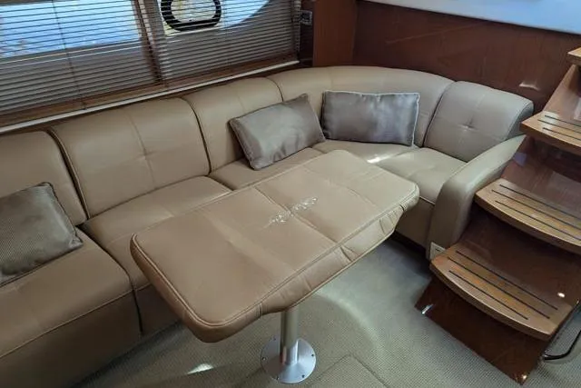 Nautalia Yacht Photos Pics Luxurious interior of 2013 Sea Ray 470 Sundancer with beige leather seating and table.