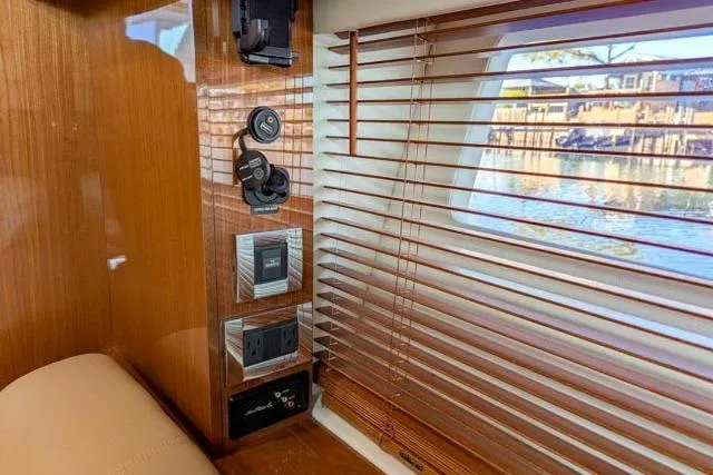 Nautalia Yacht Photos Pics Interior of 2013 Sea Ray 470 Sundancer yacht with wooden blinds and control panel.