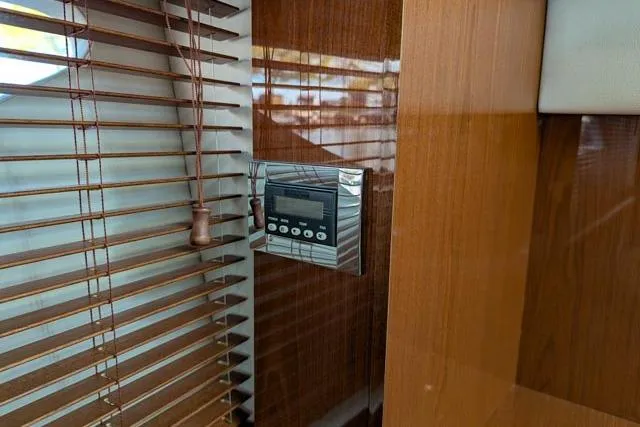 Nautalia Yacht Photos Pics Control panel on 2013 Sea Ray 470 Sundancer yacht, next to wooden blinds.