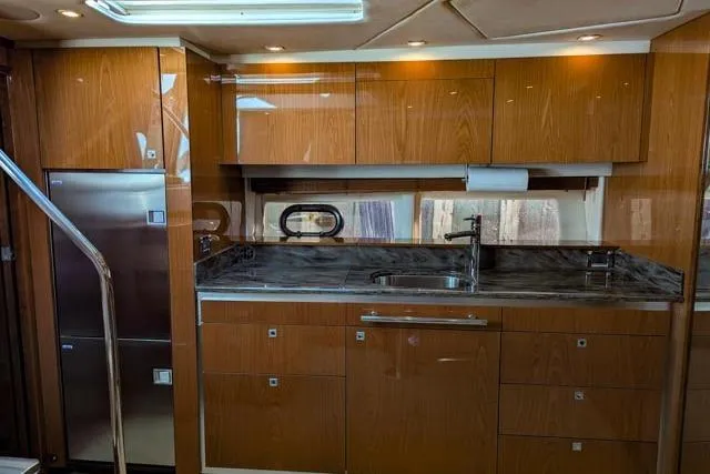 Nautalia Yacht Photos Pics Luxurious kitchen interior of 2013 Sea Ray 470 Sundancer yacht with wood cabinetry and modern appliances.