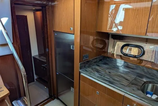 Nautalia Yacht Photos Pics Interior of 2013 Sea Ray 470 Sundancer yacht, featuring modern kitchen with wood cabinetry.