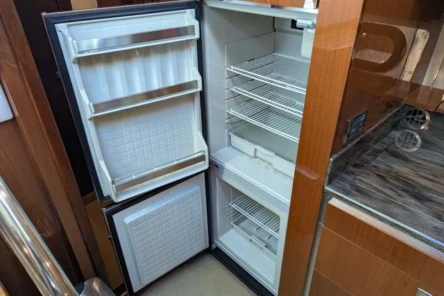 Nautalia Yacht Photos Pics Open refrigerator inside 2013 Sea Ray 470 Sundancer yacht, featuring multiple shelves and door compartments.