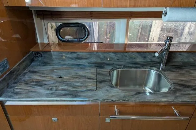 Nautalia Yacht Photos Pics Modern kitchen area in 2013 Sea Ray 470 Sundancer yacht with sleek countertop and sink.