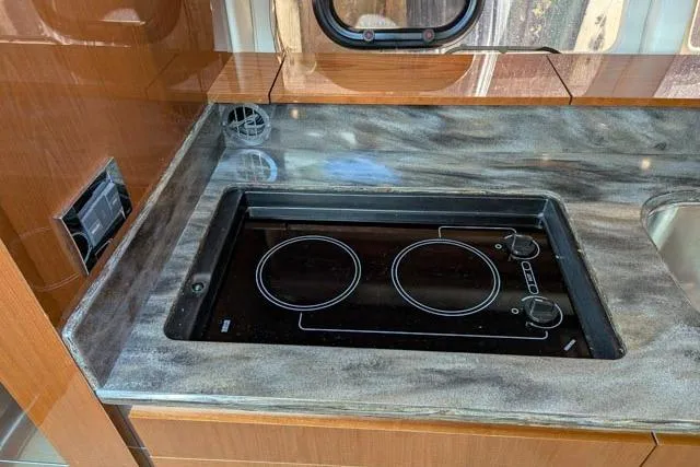 Nautalia Yacht Photos Pics Modern kitchen area on 2013 Sea Ray 470 Sundancer yacht with sleek stovetop.