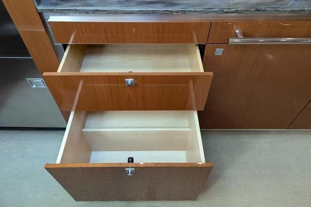 Nautalia Yacht Photos Pics Open wooden drawers in a 2013 Sea Ray 470 Sundancer yacht interior.
