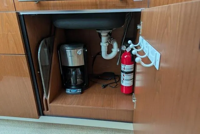 Nautalia Yacht Photos Pics Under-sink cabinet with coffee maker and fire extinguisher on Sea Ray 470 Sundancer yacht.