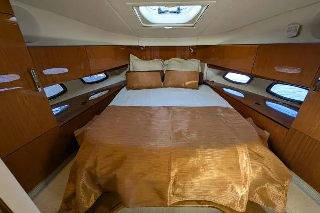 Nautalia Yacht Photos Pics Luxurious cabin interior of 2013 Sea Ray 470 Sundancer with elegant bedding and wood finishes.