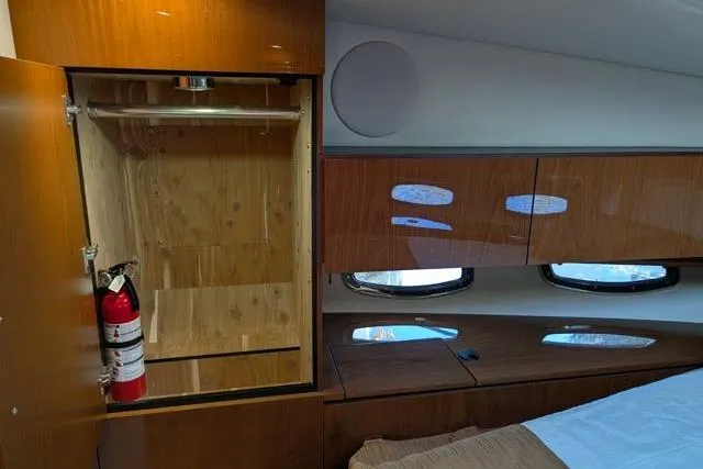 Nautalia Yacht Photos Pics Interior of 2013 Sea Ray 470 Sundancer with wooden cabinets and a fire extinguisher.