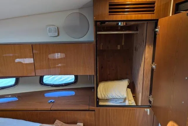 Nautalia Yacht Photos Pics Interior of 2013 Sea Ray 470 Sundancer yacht with wooden cabinetry and open closet.