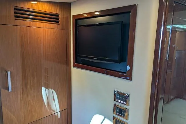 Nautalia Yacht Photos Pics Interior of 2013 Sea Ray 470 Sundancer with wall-mounted TV and wooden cabinetry.