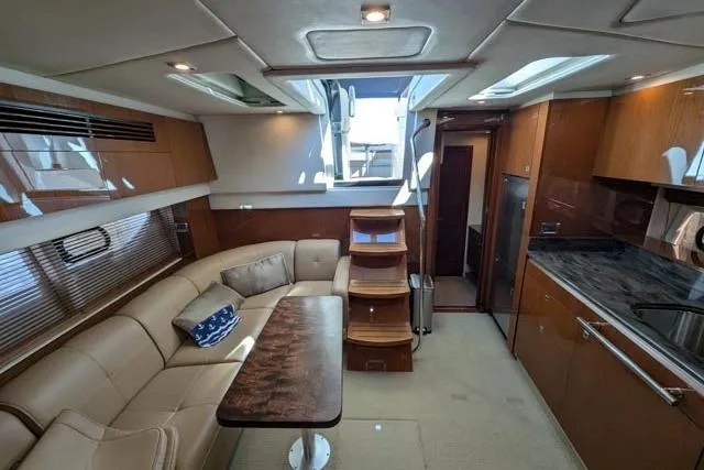 Nautalia Yacht Photos Pics Luxurious interior of 2013 Sea Ray 470 Sundancer yacht with modern kitchen and seating area.