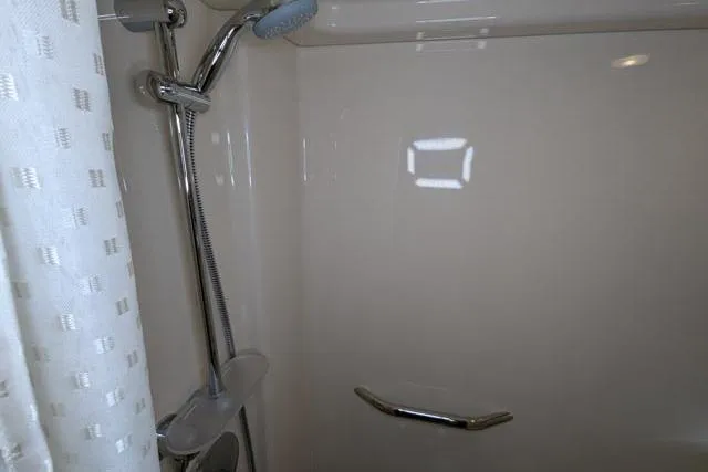 Nautalia Yacht Photos Pics Shower area in 2013 Sea Ray 470 Sundancer yacht with chrome fixtures and curtain.