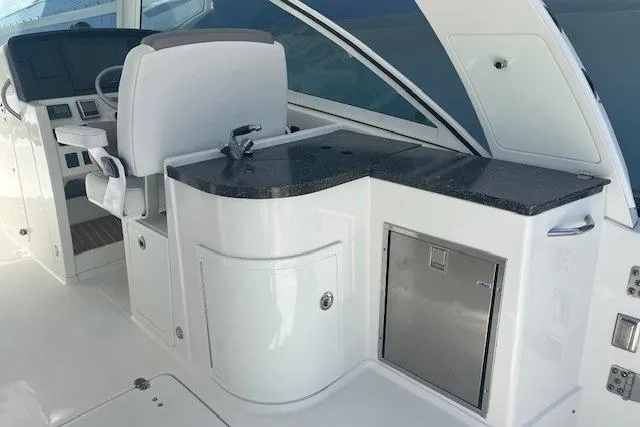  Yacht Photos Pics 2018 World Cat 320 DC boat interior with helm, seating, and kitchenette area.