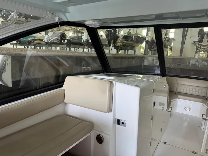  Yacht Photos Pics Interior of a 2019 Everglades 340 Dual Console boat with beige seating and large windows.