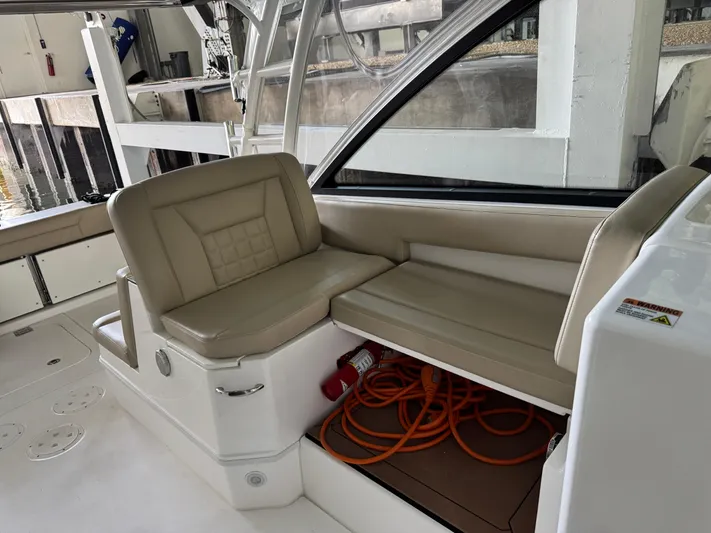  Yacht Photos Pics 2019 Everglades 340 Dual Console boat interior with beige seating and storage compartment.