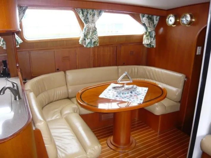 Maraya Yacht Photos Pics Luxurious interior of 1990 Cheoy Lee Sloop with leather seating and wooden table.