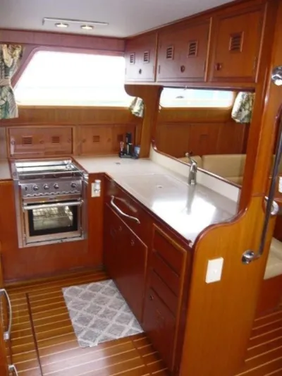 Maraya Yacht Photos Pics 1990 Cheoy Lee Sloop interior kitchen with wooden cabinetry and modern appliances.