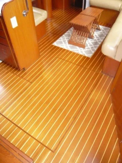 Maraya Yacht Photos Pics Interior of 1990 Cheoy Lee Sloop with polished wooden flooring and compact furniture.