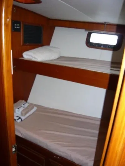 Maraya Yacht Photos Pics 1990 Cheoy Lee Sloop cabin with wooden bunk beds and a small window.