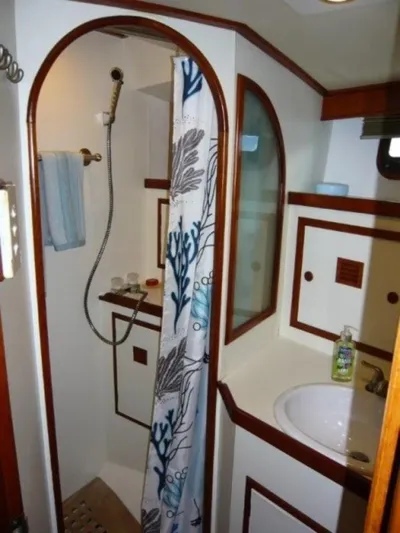 Maraya Yacht Photos Pics 1990 Cheoy Lee Sloop bathroom with shower, sink, and nautical-themed decor.