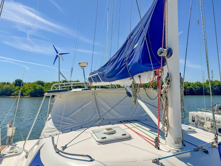 Kisa Yacht Photos Pics Sailboat Manta 42, year 2000, with blue sail cover on a sunny day by the water.