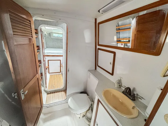 Kisa Yacht Photos Pics Bathroom interior of 2000 Manta 42 yacht, featuring sink, toilet, and wooden accents.
