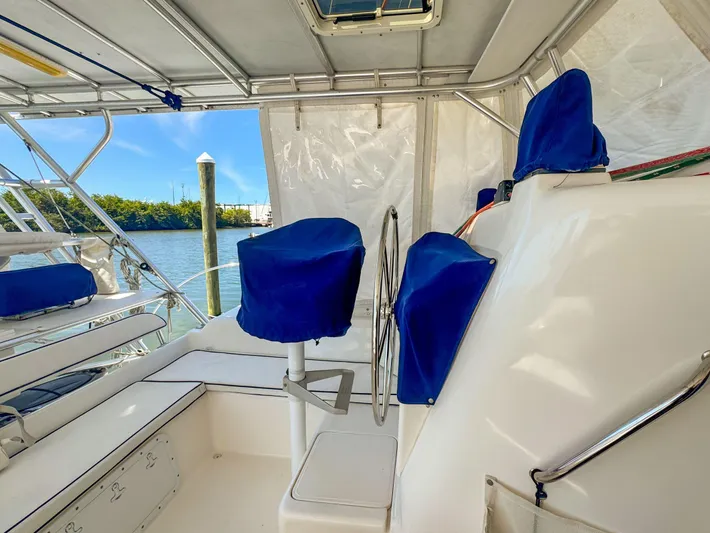 Kisa Yacht Photos Pics Interior view of 2000 Manta 42 sailboat with blue-covered seating and steering wheel.