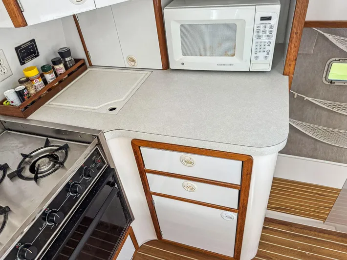 Kisa Yacht Photos Pics Compact kitchen in 2000 Manta 42 yacht with stove, microwave, and spice rack.