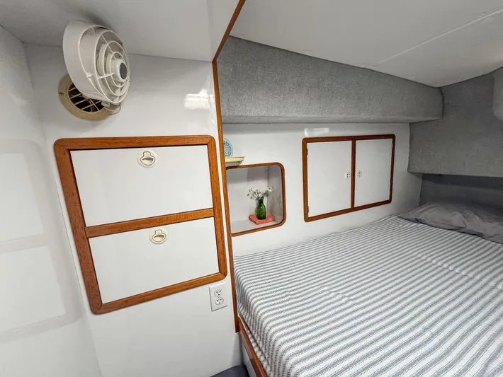 Kisa Yacht Photos Pics Cozy cabin interior of 2000 Manta 42 yacht with striped bedding and wooden storage.