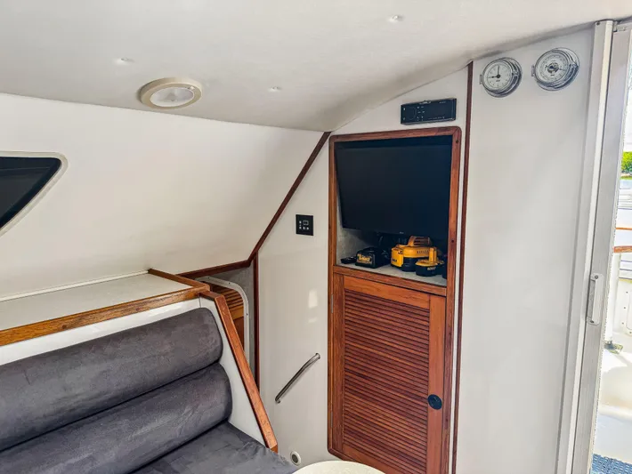 Kisa Yacht Photos Pics Interior of 2000 Manta 42 yacht with seating, TV, and wooden cabinetry.