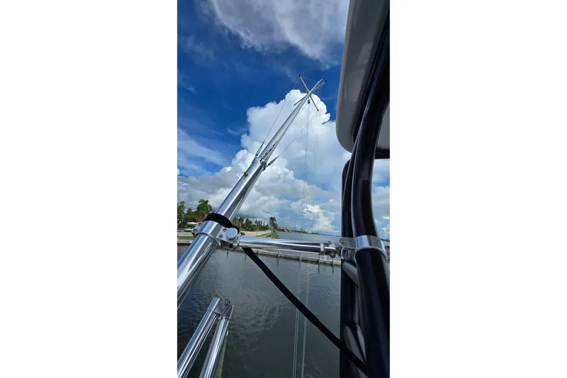 Hat Trick Yacht Photos Pics 2020 SeaVee 390Z boat with outriggers against a cloudy sky and waterfront.
