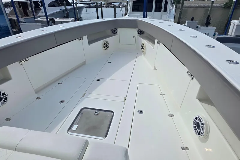 Hat Trick Yacht Photos Pics 2020 SeaVee 390Z boat deck with storage compartments and speakers at a marina.