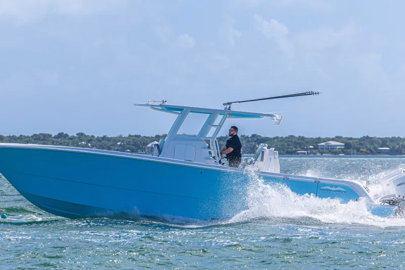  Yacht Photos Pics 2025 Invincible 35 Catamaran cruising on water, featuring sleek blue design and powerful engines.