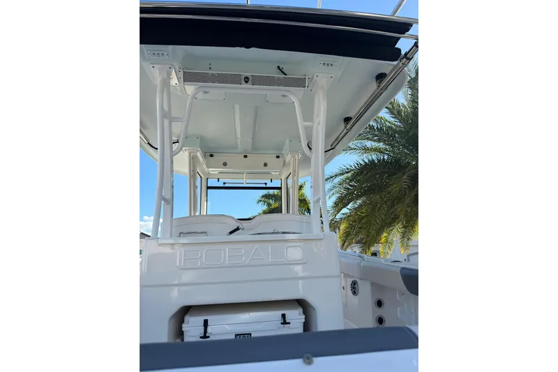  Yacht Photos Pics 2017 Robalo R302 Center Console boat with T-top, palm trees in background.