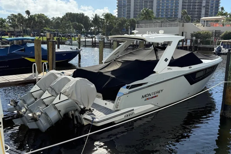  Yacht Photos Pics 2022 Monterey 385 Super Express boat docked with covered engines in a marina setting.