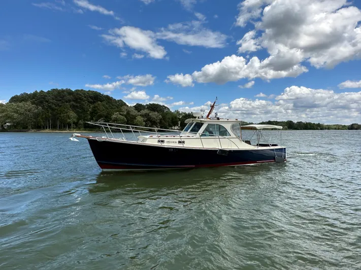  Yacht Photos Pics 2001 Mast & Mallet 38 Picnic Boat on calm water under a partly cloudy sky.