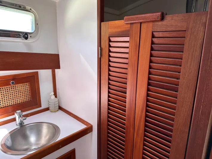  Yacht Photos Pics 2001 Mast & Mallet 38 Picnic Boat interior with wooden cabinetry and stainless steel sink.