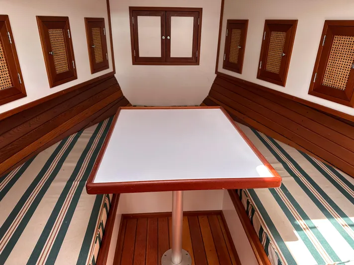  Yacht Photos Pics Interior of 2001 Mast & Mallet 38 Picnic Boat with wooden accents and striped seating.