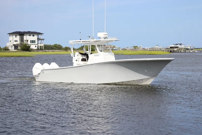  Yacht Photos Pics 2022 Onslow Bay 33 boat cruising on a calm waterway near waterfront homes.