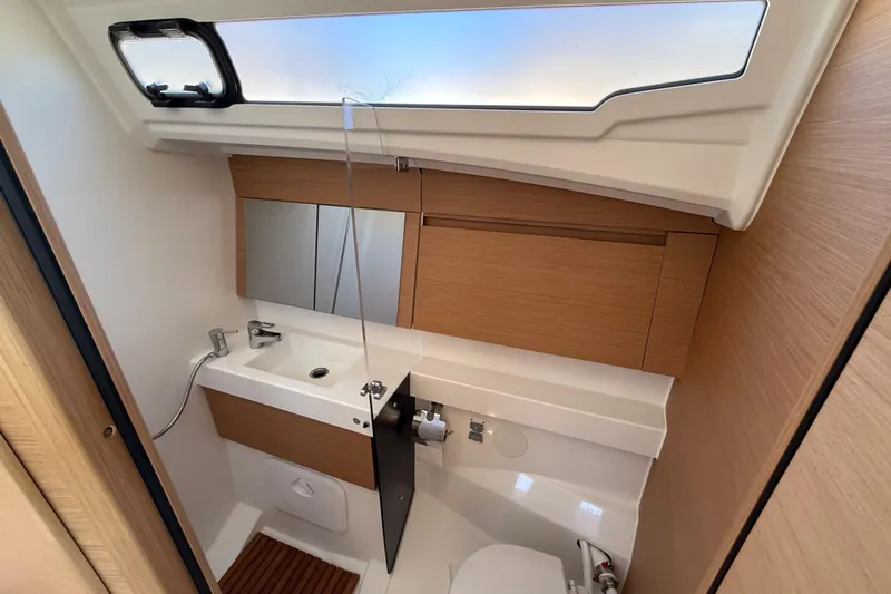 Lucky Dog Yacht Photos Pics Modern bathroom interior of 2023 Jeanneau Sun Odyssey 410 yacht, featuring sleek design and wood accents.